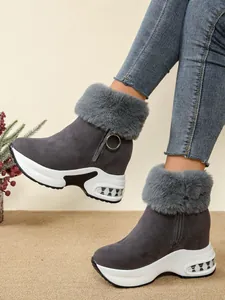 Close-up side view of women's grey suede platform wedge snow boots with faux fur collar