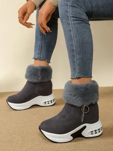 Detail shot of gray wedge snow boots with plush faux fur trim and thick white platform
