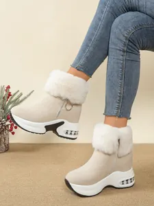 Detail of beige women's snow boots with white faux fur trim and platform wedge sole.