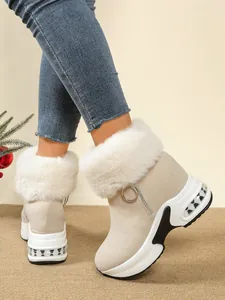 Close-up detail of beige platform wedge snow boots with plush faux fur trim and side zipper