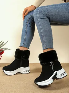 Detailed view of black platform snow boots with faux fur collar and wedge heel