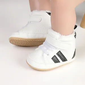 Detailed view of white baby winter boots with soft faux fur lining and black stripe accents
