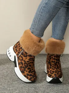 Close-up of stylish leopard print snow boots featuring brown fur trim and platform wedge sole
