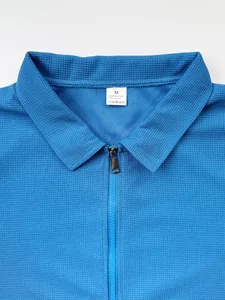 Détail du col d'une veste bleue pour homme avec fermeture éclair et étiquette M.