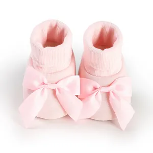 Vue rapprochée de chaussures chaussettes roses pour bébé avec un grand nœud décoratif