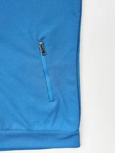 Vue détaillée de la poche zippée et de la texture gaufrée d'une veste bleue pour hommes