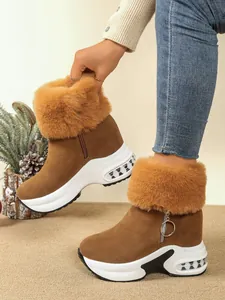 Close-up of brown platform snow boots with thick fur trim and side zipper