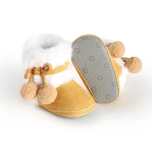Macro view of soft-soled yellow baby boots with white faux fur and anti-slip sole