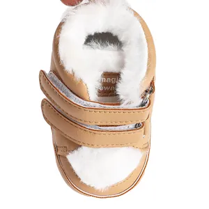 Close-up view of warm white faux fur lining and double Velcro straps on tan baby bootie