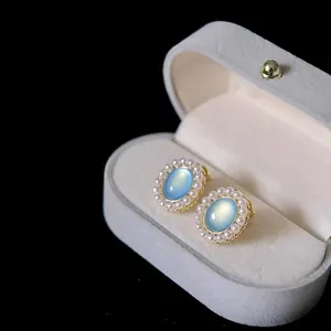 Elegante Vintage-Ohrstecker mit blauem Katzenauge und Perlenkranz in grauer Samtbox
