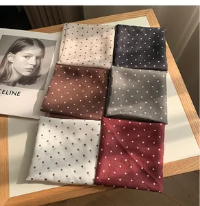 Sélection de foulards carrés en coton et lin à pois, élégamment pliés sur un plateau