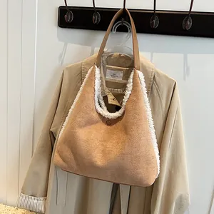 Stijlvolle bruine imitatie suède schoudertas met witte fleece rand aan een kapstok hangend.