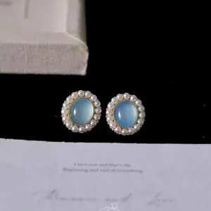 Nahaufnahme der feinen Details von Retro-Ohrringen mit blauem Katzenauge und Perlen