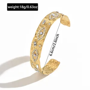Gold stainless steel eye-pattern cuff bracelet showing 6.6cm diameter and 18g weight