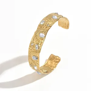 Detailed view of gold-plated stainless steel cuff bracelet with marble stones and crystals.