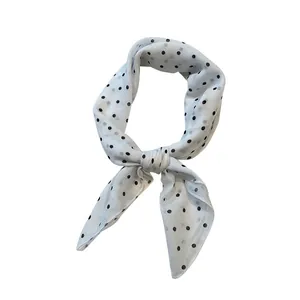 Petit foulard carré de 58cm en coton et lin blanc avec pois noirs, noué avec élégance
