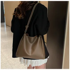 Detailed view of large brown leather tote bag styled with a chic black blazer