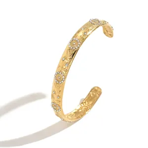 Luxury gold-plated stainless steel C-shaped bangle featuring floral and celestial patterns