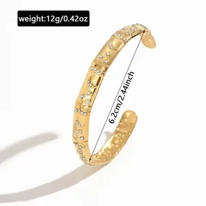 Detail view of gold stainless steel bangle with star moon patterns showing 6.2cm diameter
