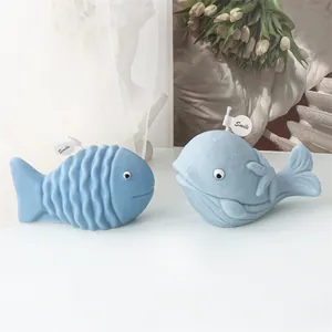 Dettaglio di candele decorative blu a forma di balena e pesce con cartellini