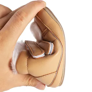 Close-up detail of flexible baby winter shoe with soft fleece lining and camel finish