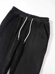 Close-up of black fleece men's sweatpants with white drawstring and elastic waist