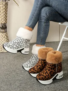 Detailed view of leopard print snow boots with thick wedge soles and faux fur lining