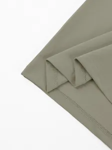 Gedetailleerde macro-opname van hoogwaardige piqué stof en zoomstiksel op olijfgroen poloshirt