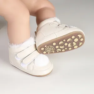 Detail of baby winter boots with non-slip sole and soft faux fur pom-poms accents