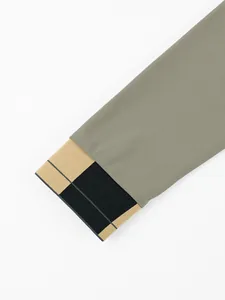 Nahaufnahme der Polo-Manschette für Herren mit grauem Piqué-Stoff und Streifen-Ripp-Detail.