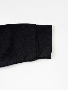Vue détaillée de la texture gaufrée noire sur le poignet d'une veste décontractée pour homme