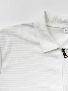 Gros plan sur la texture gaufrée blanche et la fermeture éclair de la veste pour hommes