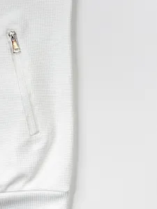 Détail du relief gaufré blanc et de la poche à fermeture éclair sur veste pour homme