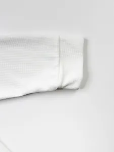 Gros plan sur le tissu gaufré blanc de la manche d'une veste décontractée pour hommes