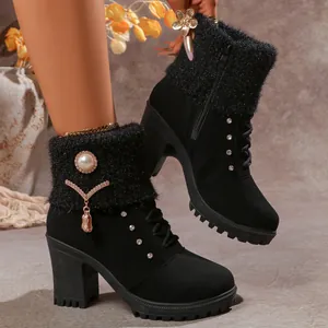 Detailed shot of black heeled boots with fluffy collar and rhinestone pearl brooch