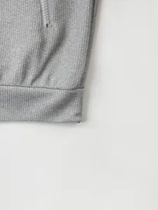 Détail du tissu gaufré gris et de la poche zippée sur une veste décontractée pour hommes