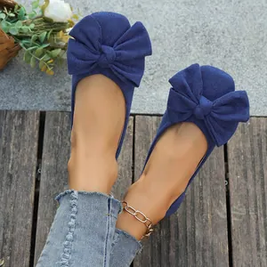 Vista ravvicinata dettagliata di ballerine in camoscio blu navy con grande fiocco decorativo
