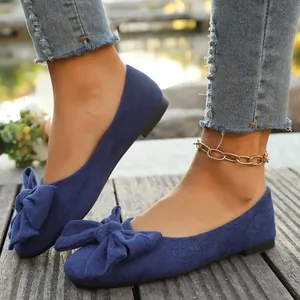 Vista dettagliata di eleganti ballerine in camoscio blu con un grande fiocco decorativo