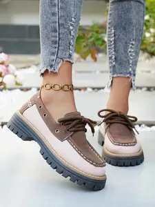 Vista detallada de elegantes mocasines con plataforma en rosa y marrón con cordones