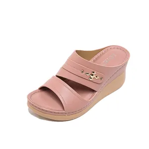 Pink wedge sandals with faux leather straps and gold-tone geometric buckle.