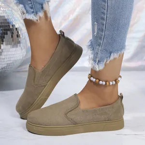 Primer plano de elegantes mocasines de plataforma color topo usados con vaqueros desgastados