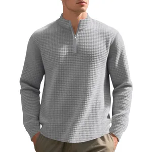 Dettaglio della felpa grigia da uomo con mezza zip e trama a nido d'ape in maglia jacquard.