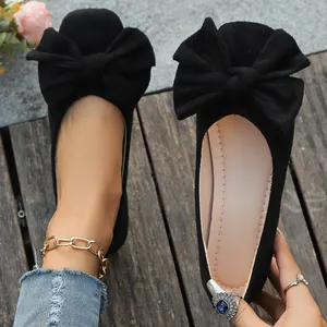 Vista dettagliata delle ballerine in pelle scamosciata nera con grande fiocco