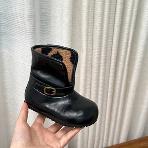 Gros plan de bottines en cuir noir pour filles avec doublure polaire léopard doux