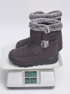 Dark brown waterproof snow boots weighed on a digital scale showing 0.420kg