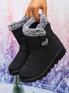 Detailed view of black waterproof snow boots with grey faux fur lining and Velcro strap