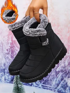 Close-up of women's black waterproof snow boots with thick faux fur lining and velcro strap