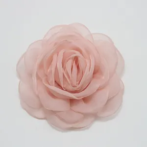 Detalle macro de una rosa de organza rosa de 8 cm con pétalos de tela en capas reales.