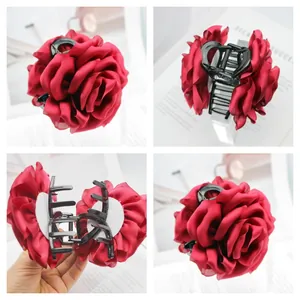 Detailed views of a large dark red satin rose hair claw clip for elegant bun styling.