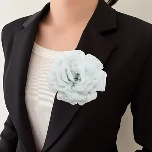 Grande spilla e fermaglio per capelli a forma di peonia verde menta su un blazer nero
